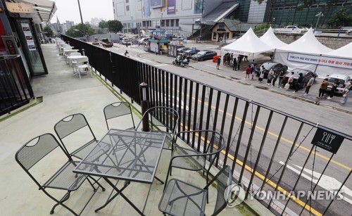 서울시 '5명 이상 모임 금지' 유지 지난달 30일 오후 서울 신촌역 앞 야외 음식점 모습. 부근 선별진료소에서 시민들이 코로나19 검사를 받기 위해 대기해 있다. [연합뉴스 자료사진]