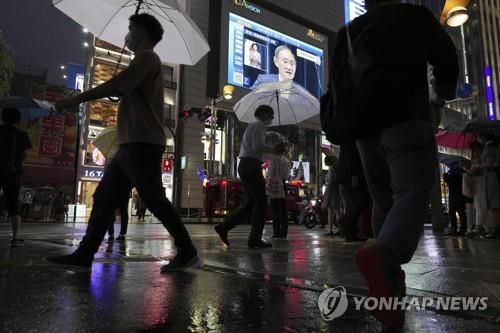 (도쿄 AP=연합뉴스) 8일 오후 일본 도쿄도(東京都)에 설치된 대형 모니터에 스가 요시히데(菅義偉) 일본 총리의 기자회견 장면이 중계되고 있다.