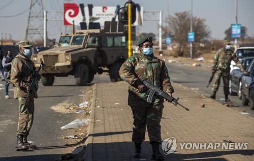 14일 요하네스버그 동쪽 보슬루어루스의 한 상가몰 밖에서 순찰하는 군인들[AP=연합뉴스]