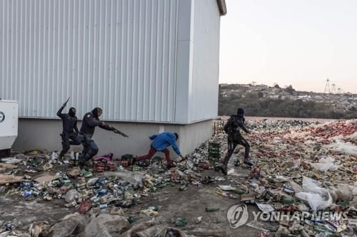 16일 남아공 더반에서 경찰이 고무탄을 쏘며 약탈자를 쫓고 있다.[AFP=연합뉴스]