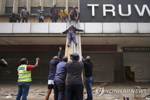 지난 13일 더반의 한 불타는 건물에서 주민들이 소개되고 있다.[AP=연합뉴스]