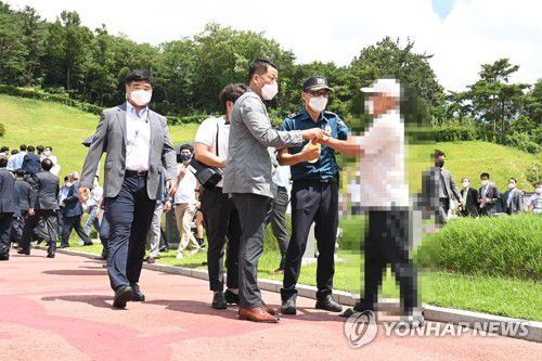 윤석열 5·18 묘지 참배 '항의'(광주=연합뉴스) 박철홍 기자 = 대선 예비후보인 윤석열 전 검찰총장이 17일 오전 광주 북구 국립 5·18민주묘지를 참배한 가운데 윤 전 총장의 참배를 항의하려는 시민이 제지받고 있다. 2021.7.17 pch80@yna.co.kr