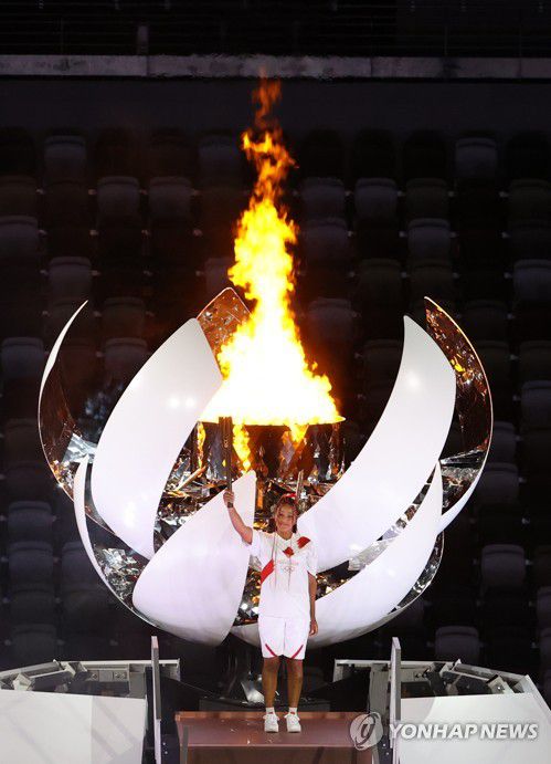[올림픽] 성화 마지막 주자는 오사카 나오미(도쿄=연합뉴스) 김인철 기자 = 여자 테니스 세계랭킹 2위인 일본 오사카 나오미가 23일 일본 도쿄 신주쿠 국립경기장에서 열린 2020 도쿄올림픽 개막식에서 성화대에 점화한 뒤 성화를 들어 보이고 있다.   2021.7.23 yatoya@yna.co.kr