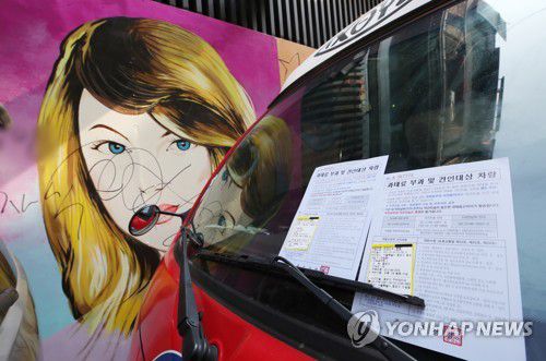 '쥴리 벽화' 막아선 차량에 붙은 주차위반 과태료 부과서(서울=연합뉴스) 임헌정 기자 = 30일 오전 서울 종로구의 한 서점 외벽에 그려진 대권 주자 윤석열 예비후보의 부인 김건희 씨를 비방하는 내용의 벽화를 막아선 차량에 주차위반 과태료가 붙어 있다. kane@yna.co.kr