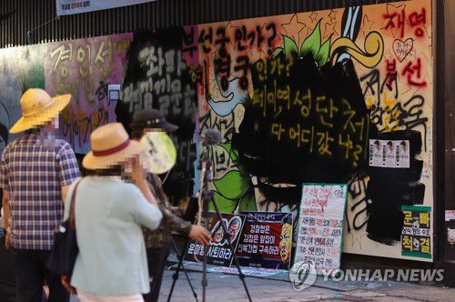 검은색 페인트 덧칠 된 '쥴리 벽화'(서울=연합뉴스) 서명곤 기자 = 서울 종로구 관철동의 한 중고서점 앞에 윤석열 전 검찰총장 아내 김건희 씨를 비방하는 내용의 벽화가 게시돼 논란이 이어지는 가운데 한 유튜버가 벽화 위에 검은색 페인트로 덧칠했다.     사진은 31일 검은색 페인트로 덧칠된 벽화. 2021.7.31 seephoto@yna.co.kr