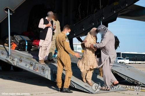 프랑스 파리에 도착한 아프가니스탄인들(파리 AFP=연합뉴스) 프랑스 군용기를 타고 이슬람 무장조직 탈레반이 장악한 아프가니스탄을 탈출한 아프간인들이 25일(현지시간) 파리 샤를드골 공항에 도착했다. [기사 제작용으로만 사용 가능. 마케팅 및 광고 목적으로 사용 금지.]