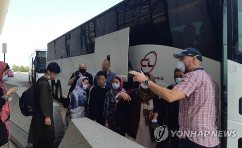 미국 도착한 아프간 피란민들(워싱턴=연합뉴스) 류지복 특파원 = 탈레반이 장악한 아프가니스탄에서 대피한 현지인들이 25일(현지시간) 오전 미국 워싱턴DC 인근 덜레스 공항에 도착한 뒤 입국 수속을 마치고 임시 수용시설로 가기 위해 버스 탑승을 기다리고 있다. 2021.8.26 jbryoo@yna.co.kr
