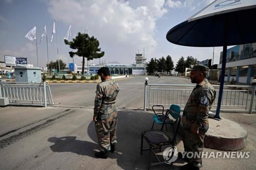 12일 카불 하미드 카르자이 국제공항의 출입구를 지키고 있는 아프간 국경 경찰 대원. [AFP=연합뉴스]