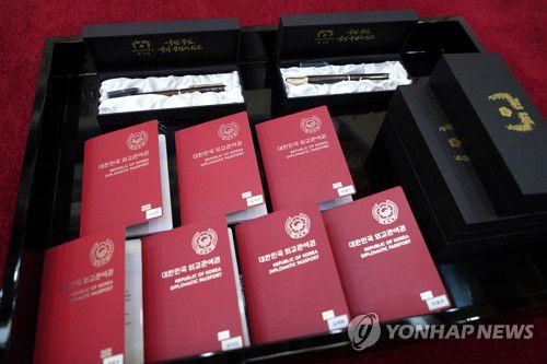 문재인 대통령이 BTS 멤버들에게 전한 외교관 여권(서울=연합뉴스) 최재구 기자 = 문재인 대통령이 14일 청와대에서 열린 미래세대와 문화를 위한 대통령 특별사절 임명장 수여식에서 그룹 BTS에게 임명장을 수여했다. 사진은 이날 BTS 멤버들에게 전해진 외교관 여권과 기념품(만년필). 2021.9.14 jjaeck9@yna.co.kr