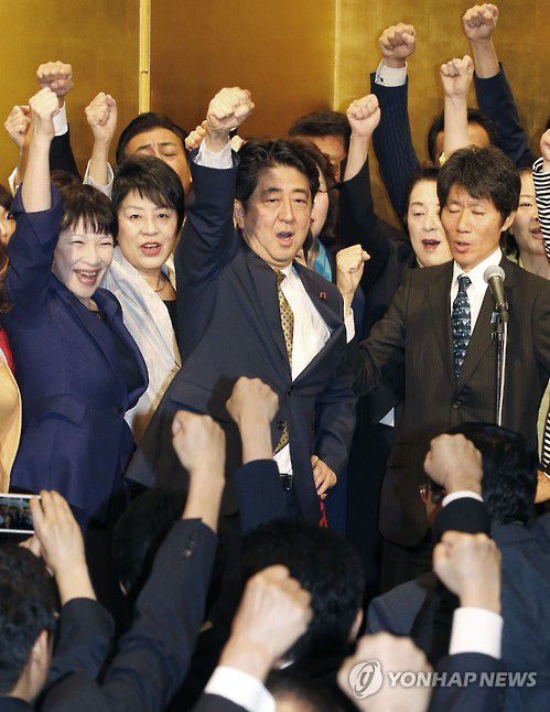 (도쿄 교도=연합뉴스) 2015년 9월 8일 아베 신조(安倍晋三, 가운데) 당시 일본 총리가 도쿄의 한 호텔에서 열린 자민당 총재 선거 출정식에서 주먹 쥔 손을 치켜들고 있다.
