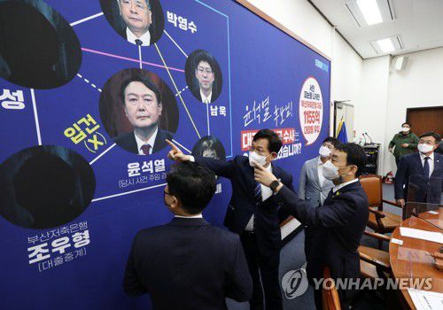 대장동 개발 의혹 관련 배경판 보는 민주당 송영길 대표(서울=연합뉴스) 안정원 기자 = 더불어민주당 송영길 대표와 최고위원들이 18일 오전 국회에서 열린 최고위원회의에 앞서 대장동 개발 의혹 관련, 부산저축은행 수사를 지적하는 내용이 담긴 배경판을 바라보며 대화를 나누고 있다. 2021.10.18 [국회사진기자단] jeong@yna.co.kr