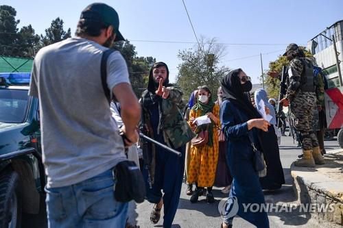 취재진에게 경고하는 탈레반 대원(카불 AFP=연합뉴스) 21일(현지시간) 아프가니스탄 수도 카불에서 여성 시위 현장을 취재하는 기자에게 경고를 보내는 탈레반 대원. 2021.10.21. photo@yna.co.kr
