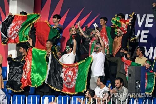 아프간 크리켓팀을 응원하는 관객 (샤르자 AFP=연합뉴스) 25일(현지시간) 아랍에미리트(UAE) 샤르자에서 열린 T20 크리켓 월드컵 대회에서 아프가니스탄 전 정부의 국기를 들고 아프간팀을 응원하는 관객. 2021.10.25. photo@yna.co.kr