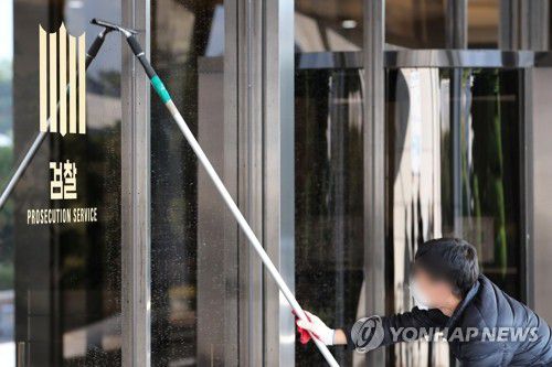 대장동 수사답보 검찰, 돌파구 깨끗이 찾을까? 성남 대장동 비리 의혹에 대한 검찰 수사가 답보 상태인 22일 오전 서울 서초구 서울중앙지검 관계자가 검찰 마크가 붙은 유리를 청소하고 있다. [연합뉴스 자료사진]