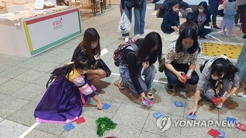 "딱지가 잘 안 뒤집히네…"(홍콩=연합뉴스) 윤고은 특파원 = 지난 29일 홍콩에서 시작한 한국문화 종합체험 행사 '한국광장 2021'의 딱지치기 코너. pretty@yna.co.kr