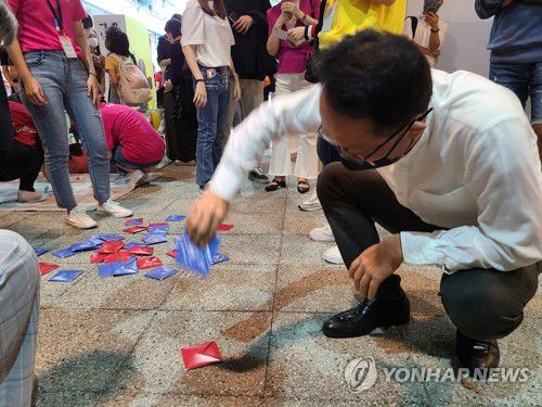 딱지치기에 도전한 백용천 주홍콩 한국총영사(홍콩=연합뉴스) 윤고은 특파원 = 지난 30일 한국문화 종합체험 행사 '한국광장 2021'에서 백용천 한국총영사가 딱지치기를 하는 모습. pretty@yna.co.kr