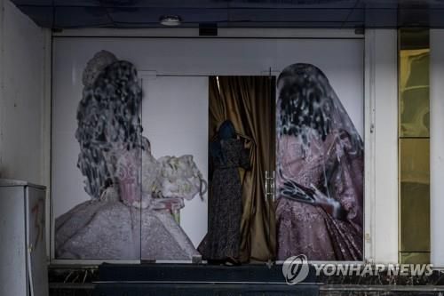 탈레반 재집권 후 광고판의 여성 얼굴이 페인트로 덧칠된 모습[AP=연합뉴스]