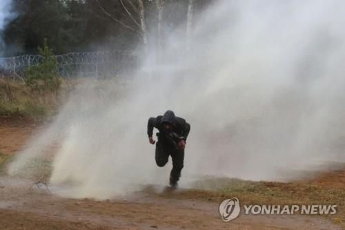 폴란드 국경경비대가 쏜 물대포 피하는 중동 난민  (그로드노 로이터/BELTA=연합뉴스) 16일(현지시간) 벨라루스와 폴란드 사이 그로드노의 브루즈기-쿠즈니차 국경검문소에 몰려든 중동 출신 난민들이 폴란드 입국을 시도하는 가운데, 한 난민 남성이 폴란드 국경경비대가 쏜 물대포를 피해 달아나고 있다. 전쟁과 빈곤을 피해 중동에서 동유럽 국가 벨라루스로 건너온 이들 난민은 새 삶을 찾아 폴란드를 통해 유럽연합(EU) 회원국으로 가길 원하고 있다. [제3자 제공. 재판매 및 DB 금지] 2021.11.17.