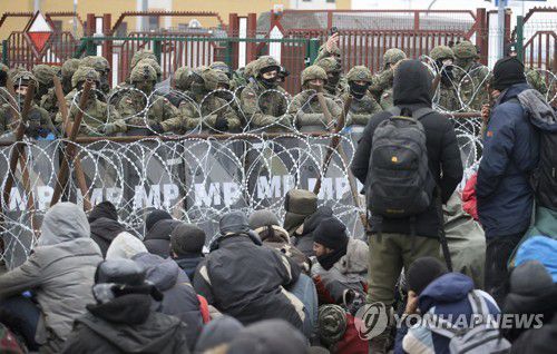 폴란드 국경수비대와 대치하는 이주민들2021년 11월 15일 중동 등지에서 온 이주민들이 폴란드-벨라루스 국경에서 월경을 넘으려는 폴란드 국경수비대와 대치하고 있다. [AP=연합뉴스 자료사진, 재판매 및 DB 금지]
