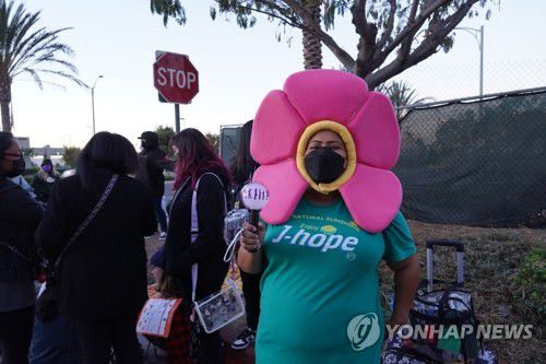 '즐길 준비 됐나요?'(로스앤젤레스=연합뉴스) 이세영 기자 = = 27일(현지시간) 방탄소년단의 콘서트 개막을 앞두고 공연장인 소파이 스타디움 입구에서 한 아미가 응원용품인 아미 밤(Army bomb)을 들고 있다. 아미가 입은 티셔츠에 BTS 멤버의 이름이 새겨져 눈길을 끈다. 2021.11.28 seva@yna.co.kr
