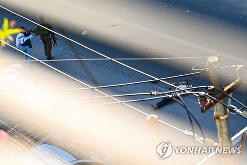 시위대 중 한 명이 부상해 길바닥에 쓰러져 있고, 다른 한 명은 군인들에게 잡혀가고 있다.[AFP=연합뉴스]