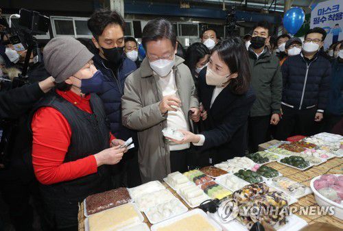 김천 황금시장에서 떡 구입하는 이재명 후보(김천=연합뉴스) 하사헌 기자 = 더불어민주당 이재명 대선 후보와 부인 김혜경 씨가 12일 조선시대 5대 시장으로 꼽히던 경북 김천시 김천 황금시장을 방문, 떡을 구입하고 있다. 2021.12.12 toadboy@yna.co.kr
