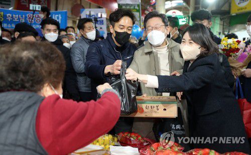 김천 황금시장에서 과일 구입하는 이재명 후보(김천=연합뉴스) 하사헌 기자 = 더불어민주당 이재명 대선 후보와 부인 김혜경 씨가 12일 조선시대 5대 시장으로 꼽히던 경북 김천시 김천 황금시장을 방문, 과일을 구입하고  있다. 2021.12.12 toadboy@yna.co.kr