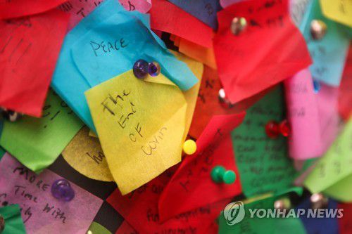 코로나19 종식을 희망하는 색종이(뉴욕 로이터=연합뉴스) 시민들의 소원을 적은 색종이가 타임스 스퀘어 앞에 전시됐다. 2021.12.20 photo@yna.co.kr