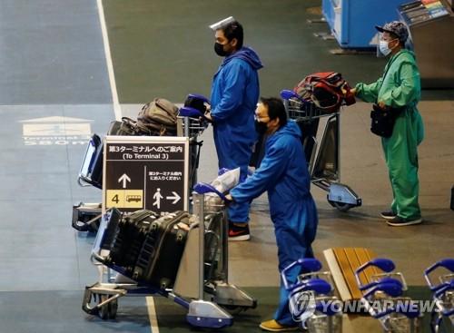 (나리타 로이터=연합뉴스) 일본 정부가 신종 코로나바이러스 감염증(코로나19) 새 변이인 오미크론 유입 차단을 위해 모든 외국인의 신규 입국을 금지한 첫날인 지난달 30일 일본 수도권 나리타 국제공항에서 방호복을 입은 여행객들이 버스 탑승을 위해 이동하고 있다.