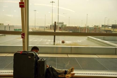 미 뉴욕 JFK 공항(뉴욕 로이터=연합뉴스) 미국 뉴욕의 존 F. 케네디 국제공항에서 24일(현지시간) 한 여행자가 바닥에 앉아 있다. 2021.12.24. photo@yna.co.kr