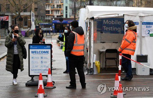 런던 코로나19 이동 검사센터(런던 EPA=연합뉴스) 24일(현지시간) 영국 런던의 코로나19 이동 검사센터 옆을 한 시민이 지나고 있다. 2021.12.25 photo@yna.co.kr