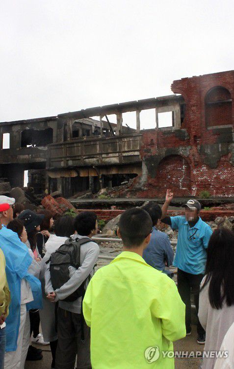 군함도에 관해 설명 듣는 관광객(나가사키=연합뉴스) 이세원 특파원 = 2015년 6월 5일 일본 나가사키현 서쪽 바다에 있는 하시마(端島, 일명 '군함도')에서 방문자들이 군함도에 관해 현지 여행업체 직원의 설명을 듣고 있다.