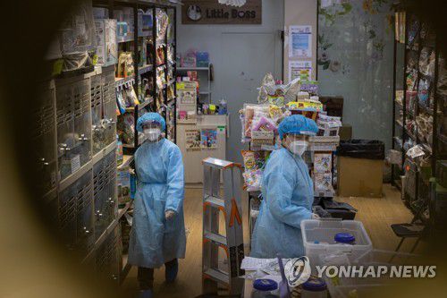 (EPA=연합뉴스) 홍콩 당국 요원들이 지난 19일 코로나19 델타 변이 환자가 발생한 코즈웨이베이의 애완동물가게를 조사하는 모습. 2022.1.20.