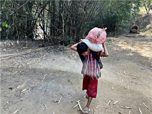 난민촌 안으로 구호품을 이고 들어오는 카렌족 아이. 2022.1.16(폽프라[태국 딱주]=연합뉴스) 김남권 특파원