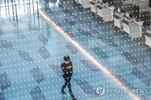 도쿄 하네다 공항 모습(도쿄 AFP=연합뉴스) 25일 일본 도쿄도(東京都) 소재 하네다(羽田)국제 공항에서 마스크를 쓴 남성이 이동하고 있다. 일본 정부가 코로나19의 변이인 오미크론을 차단하겠다며 외국인의 신규 입국을 원칙적으로 금지한 가운데 공항이 한산한 모습을 보이고 있다.