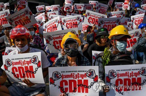 시민불복종 운동(CDM) 플래카드를 든 양곤의 시위대들. 2021.2.14.[AFP=연합뉴스 자료사진]