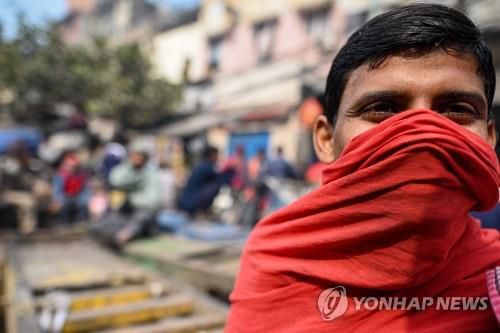 마스크 대신 천으로 입을 가린 인도 뉴델리의 한 노동자. [AFP 연합뉴스 자료사진. 재판매 및 DB 금지]