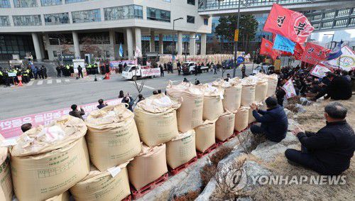 "쌀값은 농민 값! 쌀값을 보장하라!"(세종=연합뉴스) 김주형 기자 = 한국쌀전업농중앙연합회, 전국쌀생산자협회 등 4개 단체 관계자들이 14일 오후 세종시 정부세종청사 농림축산식품부 앞에 벼 이삭 포대를 쌓고 쌀값 보장을 요구하는 시위를 하고 있다. 2022.2.14 kjhpress@yna.co.kr