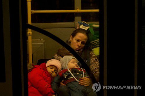 피란민을 실은 버스를 탄 가족(타간로그[러시아] AFP=연합뉴스) 19일(현지시간) 우크라이나 도네츠크를 떠나온 한 가족이 버스에서 러시아 내륙으로 가는 기차를 지친표정으로 기다리고 있다. 2022.2.19