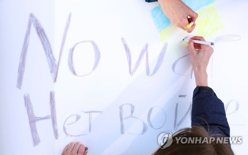 '전쟁은 그만'(서울=연합뉴스) 김도훈 기자 = 27일 오후 서울 종로구 보신각 앞에서 재한 러시아인 주최로 열린 우크라이나 전쟁 반대 집회에서 참가자들이 집회에 사용할 손팻말을 만들고 있다. 2022.2.27 superdoo82@yna.co.kr