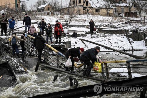 폭격으로 부서진 다리 건너는 우크라 키예프 시민들(키예프 AFP=연합뉴스) 1일(현지시간) 우크라이나 수도 키예프 북쪽에서 시민들이 폭격으로 부서진 다리의 난간을 붙잡고 위태롭게 강을 건너고 있다. 우크라이나에서는 러시아군의 무차별 폭격으로 민간인 사상자와 민간 시설의 피해가 급증하고 있다. 2022.3.2 sungok@yna.co.kr