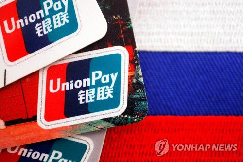 러시아 국기 위에 놓인 유니온페이 카드UnionPay cards are seen displayed with a Russian flag in this illustration picture taken March 7, 2022. REUTERS/Florence Lo/Illustration