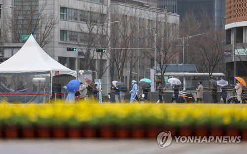 봄비 내리는 선별검사소(서울=연합뉴스) 윤동진 기자 = 봄비가 내리는 13일 오전 서울광장 임시선별검사소에서 시민들이 검사를 기다리고 있다.     중앙방역대책본부는 이날 0시 기준으로 확진자가 35만190명 늘어 누적 655만6천453명으로 집계됐다고 밝혔다. 2022.3.13 mon@yna.co.kr