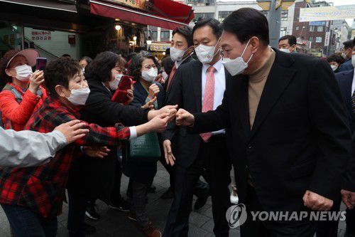 시민들과 인사 나누는 윤석열 당선인(서울=연합뉴스) 윤석열 대통령 당선인이 14일 당선 이후 첫 외부 공식일정으로 서울 남대문 시장을 찾아 상인 및 시민들과 인사를 나누고 있다. 2022.3.14 [국회사진기자단] toadboy@yna.co.kr