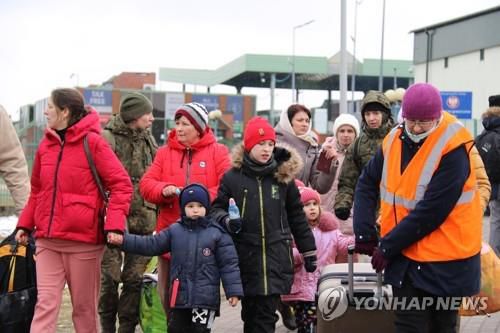 우크라이나 난민 돕는 자원봉사자(메디카[폴란드]=연합뉴스) 전성훈 특파원 = 한 자원봉사자가 지난 9일(현지시간) 폴란드 메디카 국경검문소를 빠져나오는 우크라이나인 가족의 짐을 대신 들어주고 있다. lucho@yna.co.kr