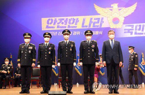 경찰 임용자 대표들과 기념촬영하는 문대통령(아산=연합뉴스) 서명곤 기자 = 문재인 대통령이 17일 오후 충남 천안 경찰대학에서 열린 2022년 신임경찰 경위·경감 임용식에서 임용자 대표 어깨에 계급장을 부착한 뒤 기념촬영을 하고 있다.   2022.3.17 seephoto@yna.co.kr