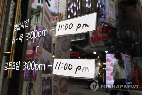 '한 시간 더 늘어날까'(서울=연합뉴스) 김주성 기자 = 17일 서울 종로구 식당가의 한 주점에 영업시간 안내문이 붙어 있다.      코로나19 확진자가 폭증하는 가운데 방역당국은 21일부터 적용할 새로운 거리두기 조정안을 18일 확정할 계획이다. 2022.3.17 utzzza@yna.co.kr