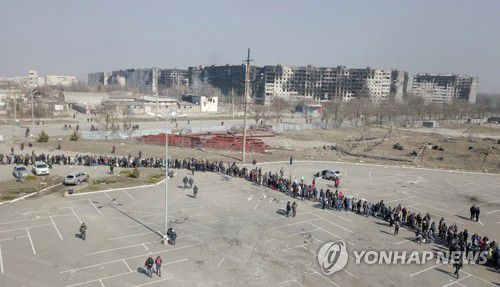 구호품 받으려 줄 선 우크라 주민들(마리우폴 로이터=연합뉴스) 러시아군 공격으로 손상을 입은 우크라이나 남부 마리우폴의 아파트 단지 인근에서 24일(현지시간) 구호품을 받으려는 주민들이 길게 줄을 서 있다.
