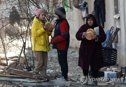 서서 끼니 때우는 우크라 마리우폴 주민들(마리우폴 로이터=연합뉴스) 우크라이나 남부 항구도시 마리우폴 주민들이 28일(현지시간) 파괴된 건물 밖에 서서 빵을 먹고 있다. 바딤 보이첸코 마리우폴 시장은 이날 미국 CNN방송 인터뷰에서 러시아군 포격으로 수많은 사상자가 발생한 마리우폴 지역 대부분이 러시아군 통제를 받고 있다고 밝혔다. 2022.3.29 leekm@yna.co.kr