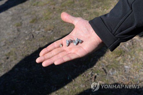 하르키우에서 러시아 집속로켓 잔해 들고 있는 남성[AFP 연합뉴스 자료사진·재판매 및 DB 금지]